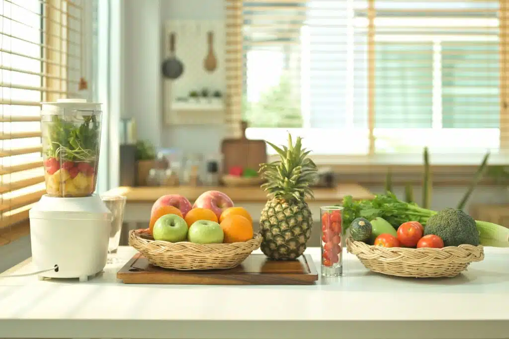 A blender and ingredients for healthy smoothie on kitchen table.